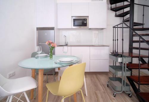 uma pequena cozinha com uma mesa azul e cadeiras amarelas em Casa da Esfarrapada em Redondela