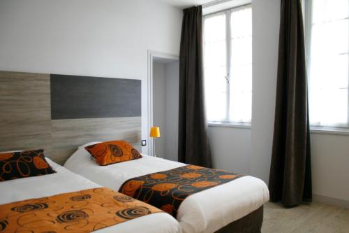 a hotel room with two beds and two windows at Logis Hostellerie de l'Abbaye in Celles-sur-Belle