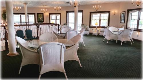 een eetkamer met witte stoelen en tafels bij Inn at Amish Door in Wilmot