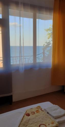 a bedroom with a window with a view of the ocean at Майстор Костадин - 1878 in Obzor