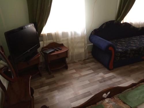 a living room with a tv and a couch and a table at Готель-Маєток in Luts'k