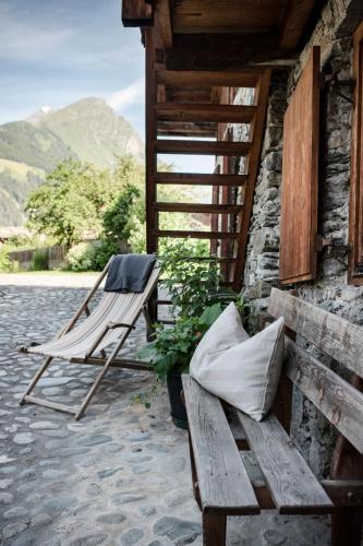 a bench and a chair sitting on a patio at Kesslerstadel in Matrei in Osttirol