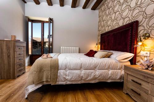 - une chambre avec un grand lit et une commode dans l'établissement RIOJAVALLEY Apartamentos, à Cenicero