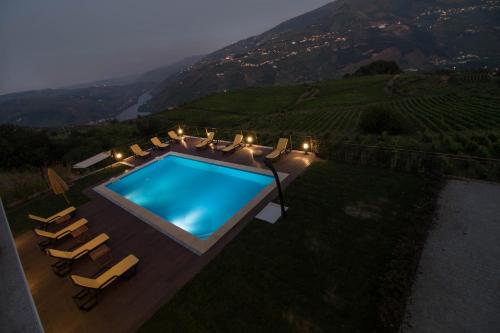 an overhead view of a swimming pool with chairs and a mountain at Vila Douro Guesthouse in Mesão Frio
