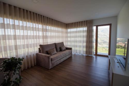 a living room with a couch and a window at Vila Douro Guesthouse in Mesão Frio