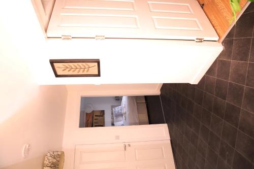 a small kitchen with white cabinets and a mirror at The Penthouse (29) in Oldham