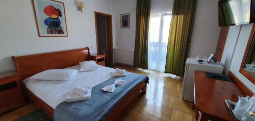 a bedroom with a bed with two napkins on it at Pensiunea Alpin Predeal in Predeal