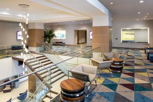 a lobby with a staircase and chairs and tables at Crowne Plaza Atlanta Midtown, an IHG Hotel in Atlanta