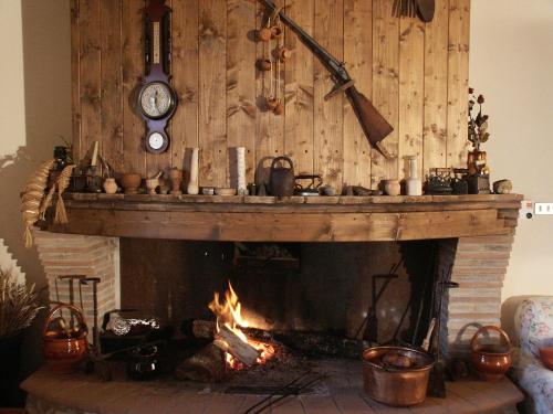a fireplace with a clock and some pots and pans at Agriturismo l'Oasi in Foligno
