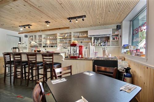 a restaurant with a bar with tables and chairs at Auberge La Chocolatiere in North Hatley