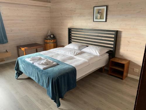 Christineborg Gjestehus Runde في Runde: غرفة نوم بسرير كبير مع بطانية زرقاء