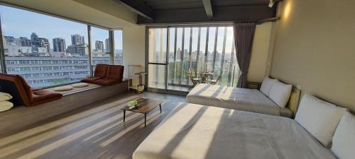 a hotel room with two beds and a large window at In Fengchia in Taichung