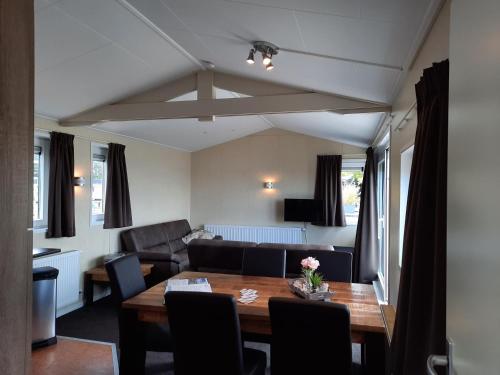 een woonkamer met een tafel en een bank bij 't Stekkie Woonboot Vinkeveense Plassen in Vinkeveen