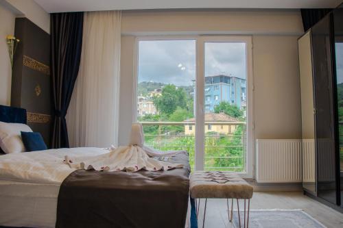 a bedroom with a bed and a large window at ELEGANT BLUE SUİTES in Trabzon