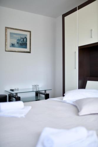 a bedroom with a white bed and a desk at Levant Residence in Sukošan