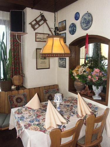 una sala da pranzo con tavolo e lampada gialla di hotel rappen a Baiersbronn