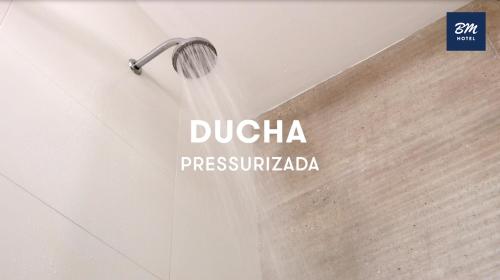 a shower head is being used in a bathroom at BM Hotel in São Sebastião do Paraíso