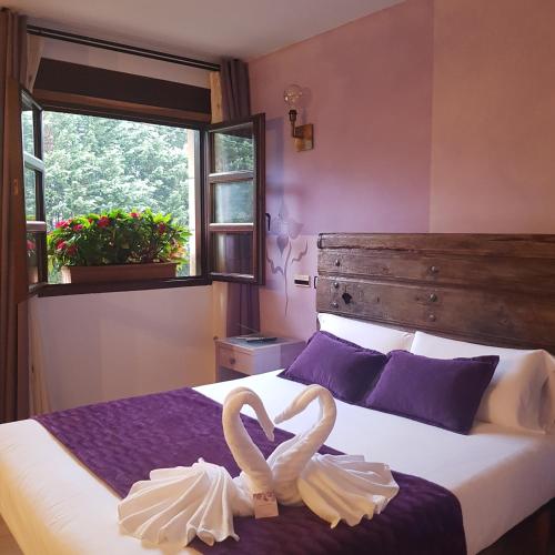 two swans are sitting on a bed in a bedroom at Posada la Leyenda in Santillana del Mar