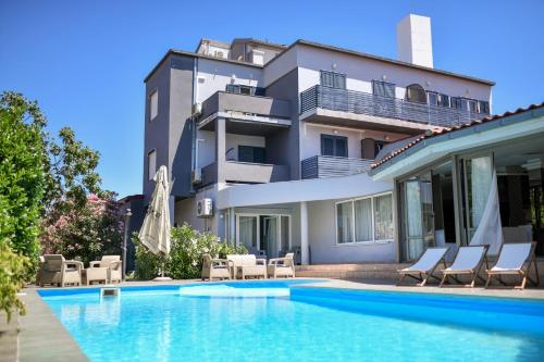una villa con piscina di fronte a un edificio di Hotel Levant a Sukošan (San Cassiano)