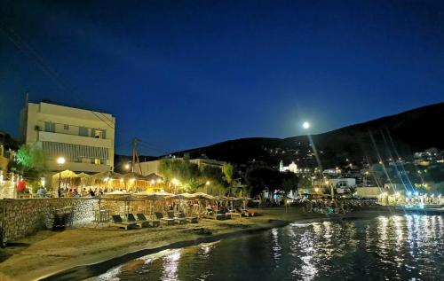 a group of people sitting on a beach at night at Venerdi Libero in Kinion