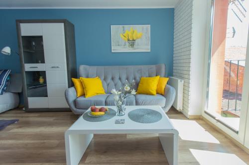 a living room with a couch and a table at Apartament u Violetty in Łeba