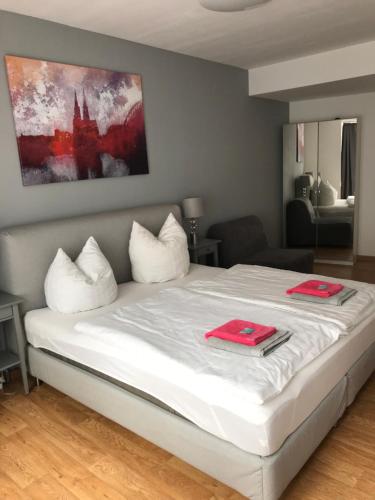 a bedroom with a bed with two red napkins on it at City Apartment am Dom in Cologne