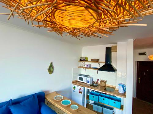 a living room with a blue couch and a kitchen at Свети Зосим in Sozopol