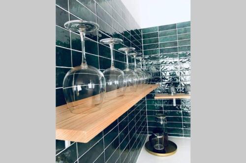 a bathroom with green tiled walls and wooden shelves at Apartament z Widokiem na Morze in Gdańsk