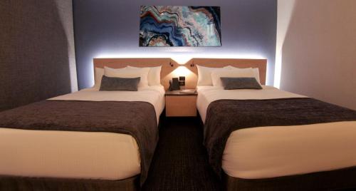 a hotel room with two beds and a lamp at QUARTZ HOTEL & SPA in Tijuana