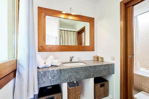 a bathroom with a sink and a mirror at Villa Sa Codolar in Cala Tarida
