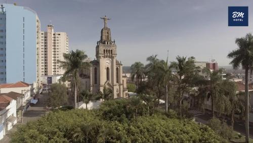 an old building with a clock tower in a city at BM Hotel in São Sebastião do Paraíso