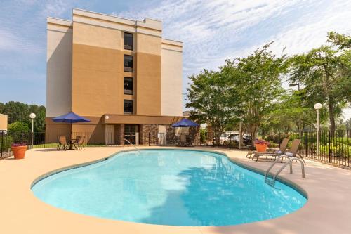 a swimming pool in front of a hotel at Baymont by Wyndham Augusta West in Augusta