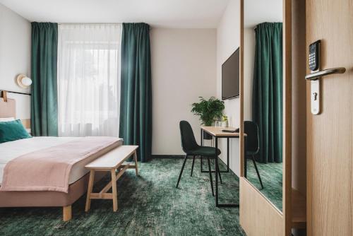 Cette chambre comprend un lit et un bureau. dans l'établissement Hi Hotel Gdansk Airport, à Gdańsk-Rębiechowo