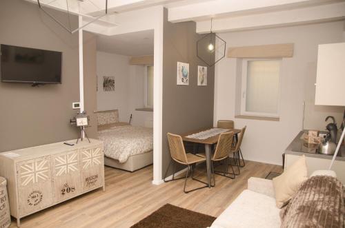salon z łóżkiem i stołem w pokoju w obiekcie appartamenti Il Borgo orchidea w mieście Busca