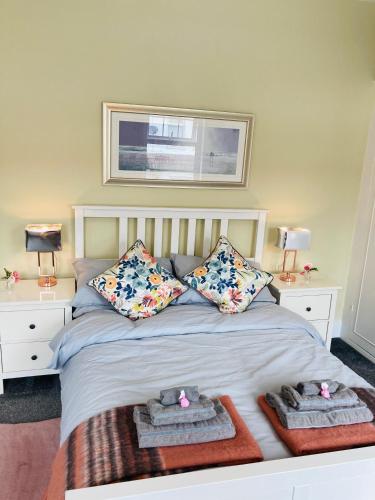 a bedroom with a bed with two pillows and towels at Beautiful Victorian Terraced House in Eastbourne