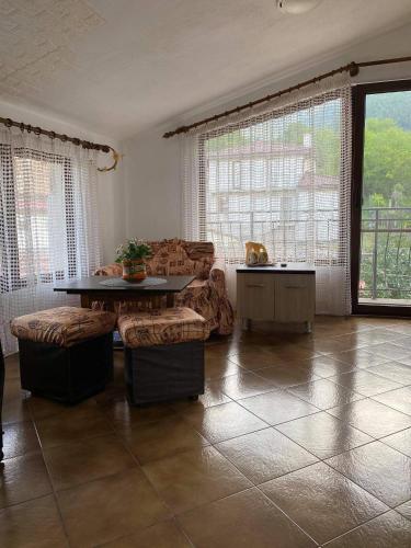 a living room with a table and chairs and windows at Art Studio in Sapareva Banya