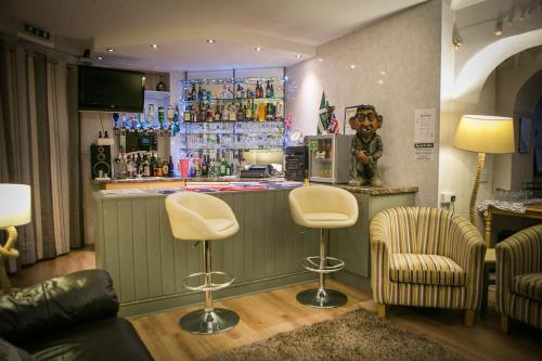 a bar with two chairs and a counter in a room at Glendower in Torquay