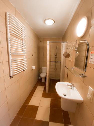a bathroom with a sink and a toilet at Pensjonat Bryza in Karwia