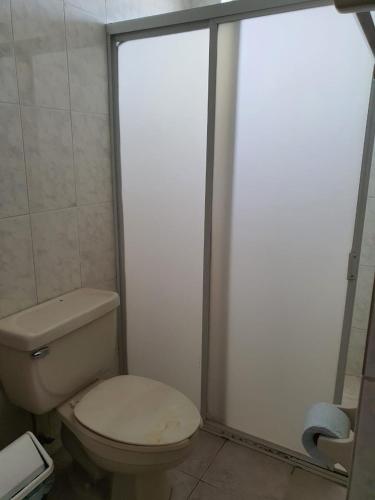 a bathroom with a toilet and a glass shower door at Hotel Atlantico a 150 mts de Playa Martí in Veracruz