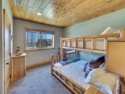 a bedroom with two bunk beds and a window at Wee-Kin-Da-Wa in Boyne Falls