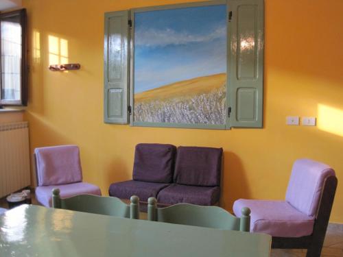 a waiting room with purple chairs and a painting on the wall at Agriturismo l'Oasi in Foligno