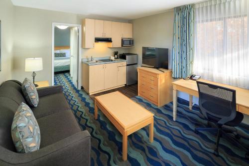a living room filled with furniture and a tv at Accent Inns Vancouver Airport in Richmond