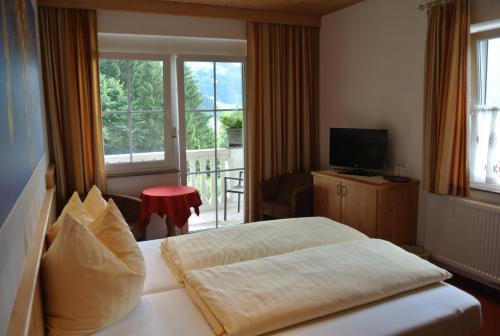 a hotel room with a bed and a balcony at Aparthotel Gallahaus in Zell am Ziller