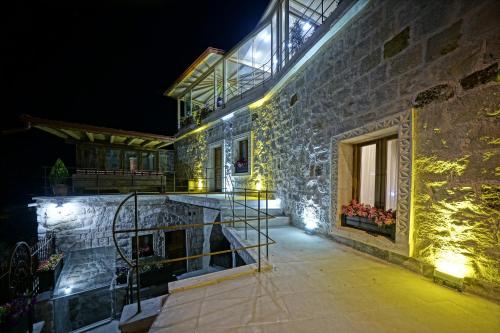 a stone building with a staircase on it at night at Vigneron Cave Hotel in Nevsehir