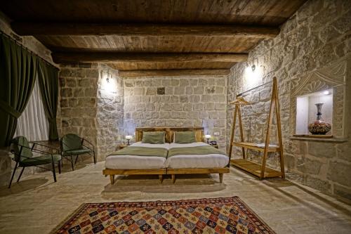 a bedroom with a bed in a stone wall at Vigneron Cave Hotel in Nevsehir
