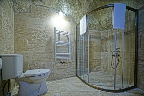 a bathroom with a toilet and a glass shower at Vigneron Cave Hotel in Nevsehir