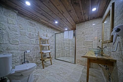 a bathroom with a toilet and a glass shower at Vigneron Cave Hotel in Nevsehir