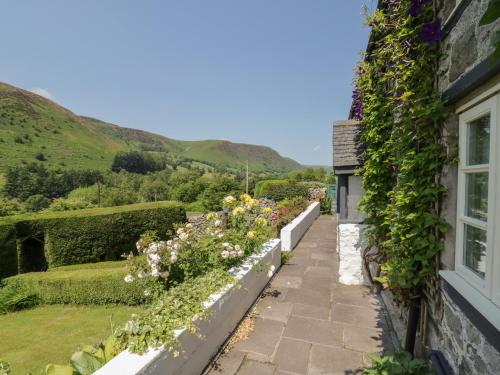 a garden outside a house with flowers on the wall at Haulfryn in Llangynog