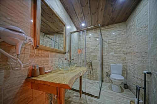 a bathroom with a sink and a shower and a toilet at Vigneron Cave Hotel in Nevsehir
