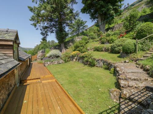 a garden with a wooden deck and a lawn at Haulfryn in Llangynog